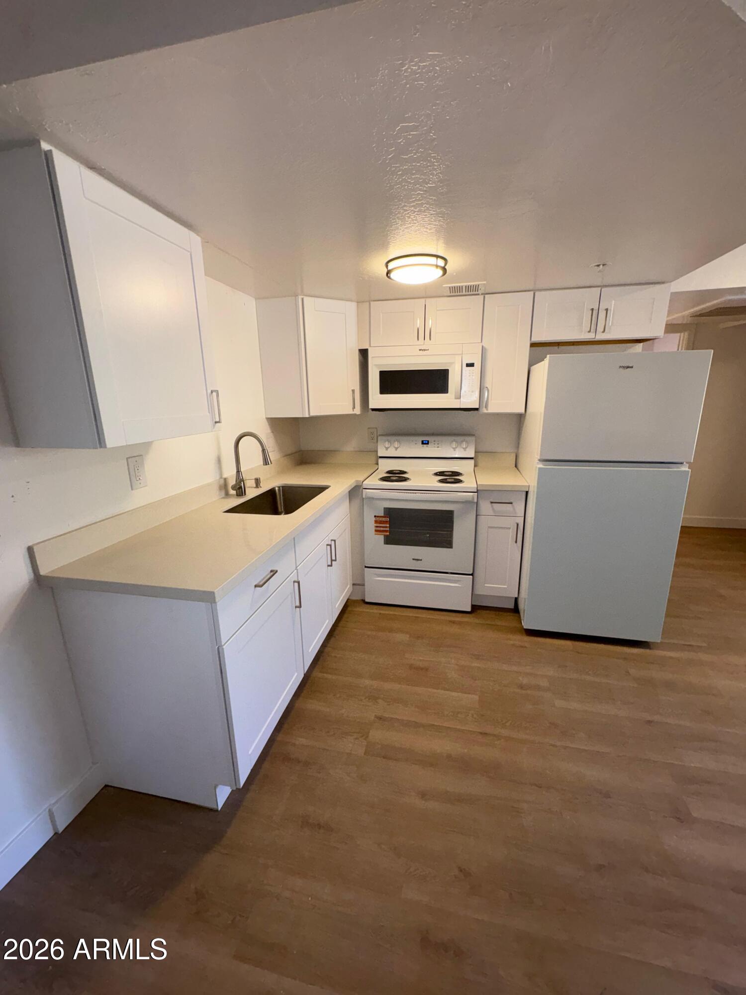 a kitchen with kitchen island a sink a stove and refrigerator