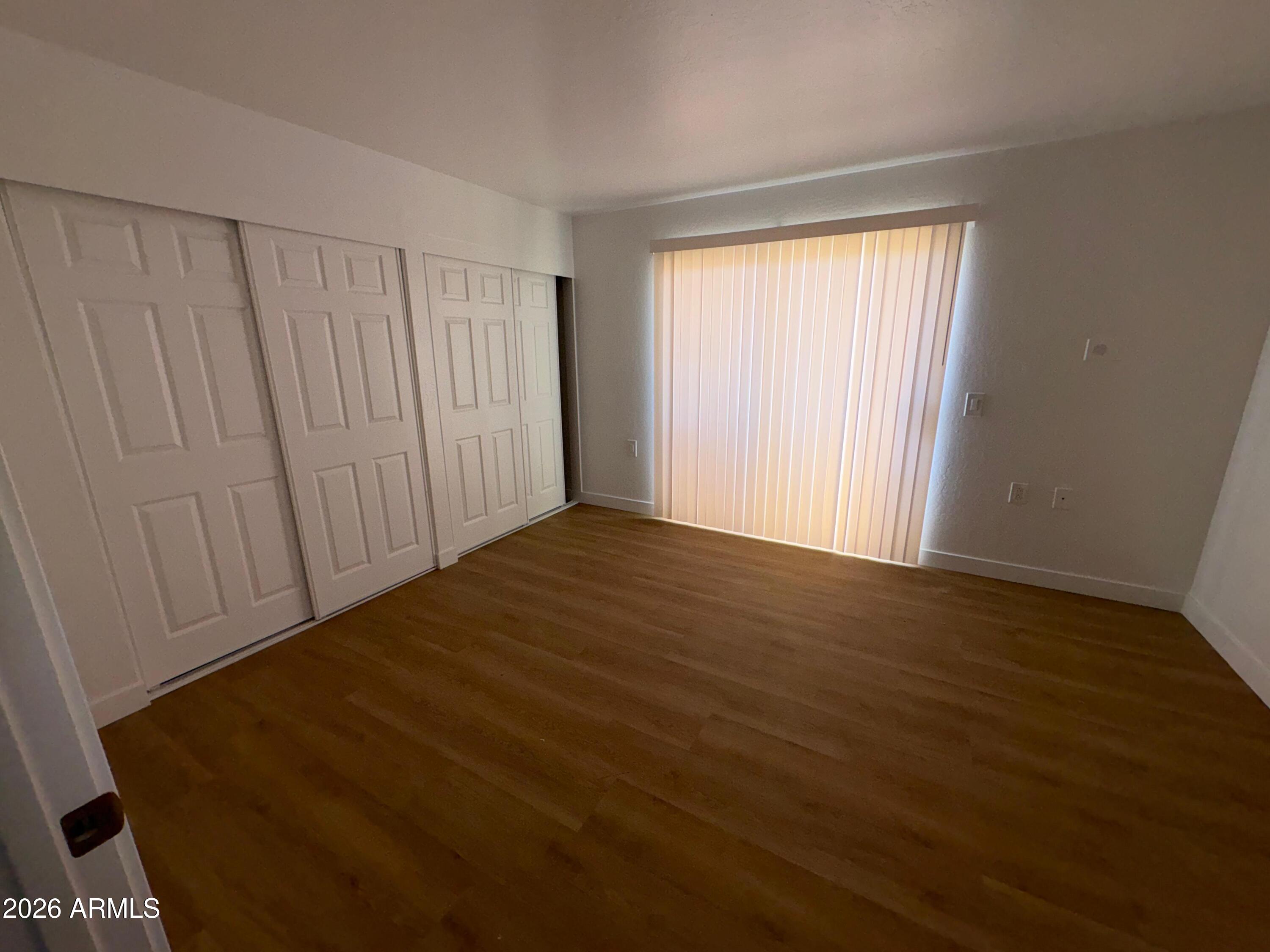 12221 West Bell Road, Unit 212 Surprise, AZ 85378 - Photo 5 of 7 a view of an empty room with wooden floor