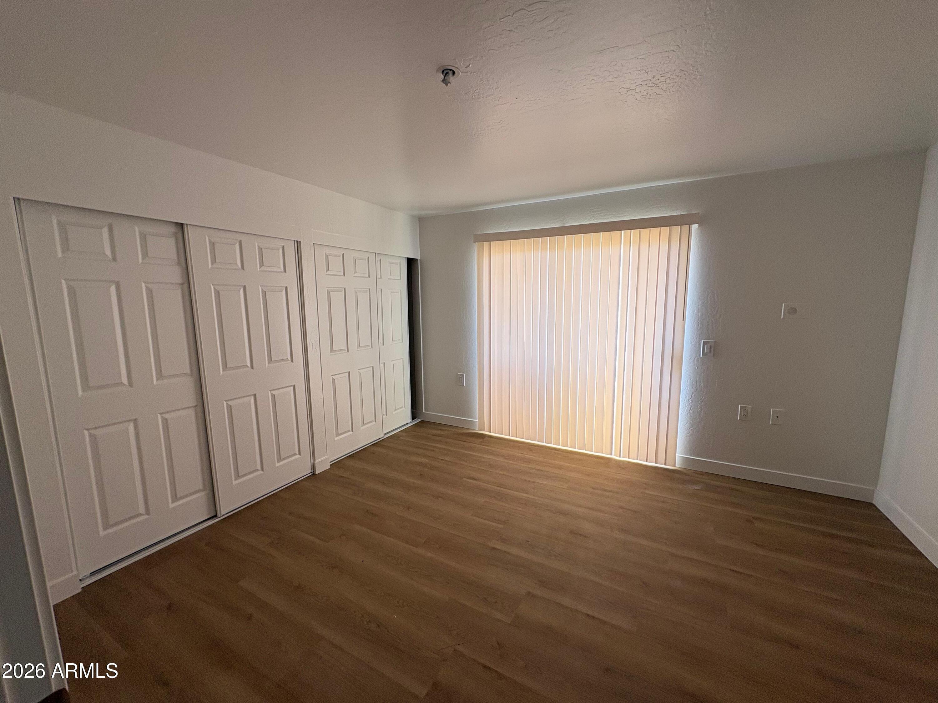 12221 West Bell Road, Unit 212 Surprise, AZ 85378 - Photo 6 of 7 a view of an empty room with wooden floor