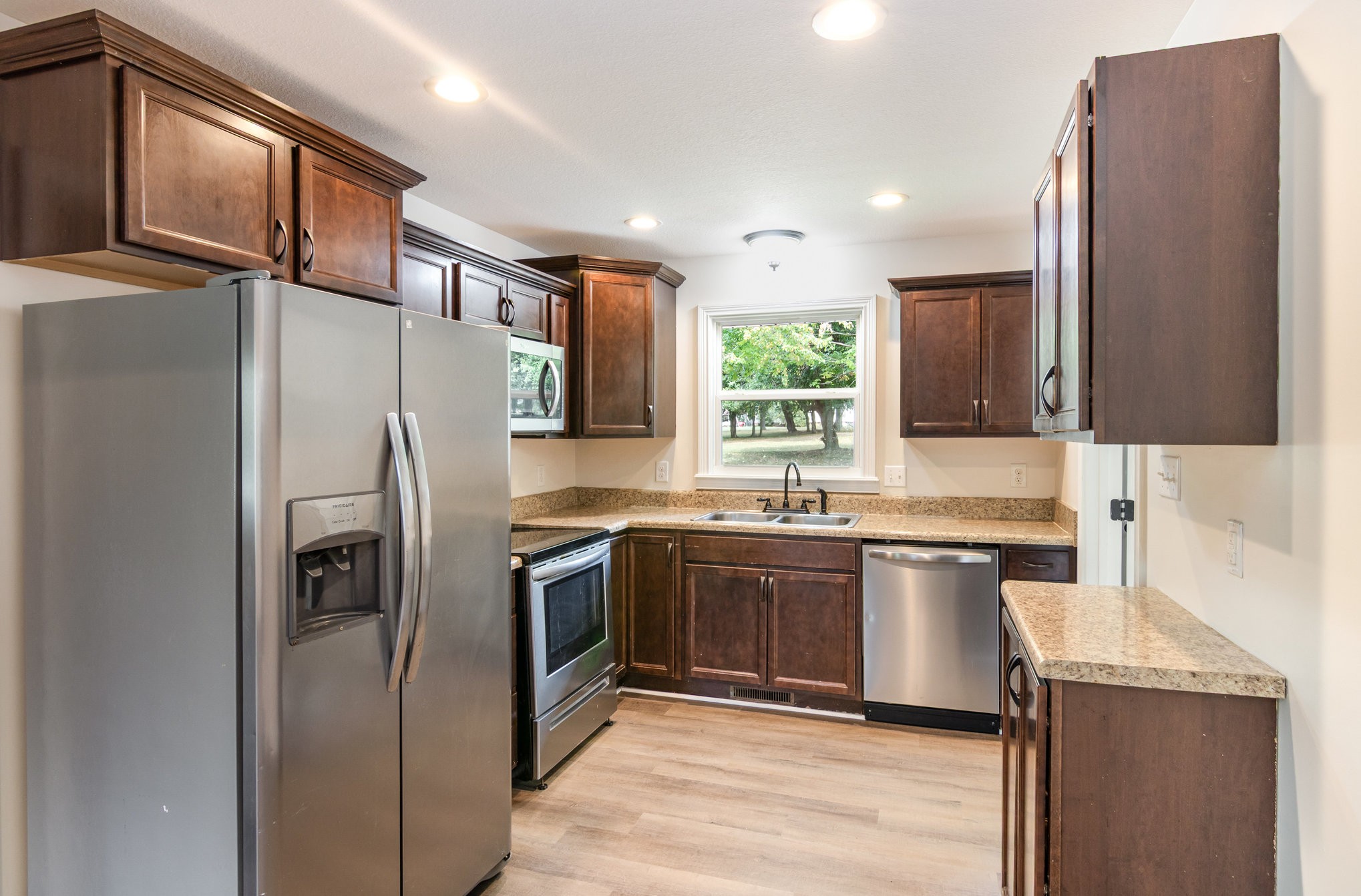 2557 Woodlawn Road Woodlawn, TN 37191 - Photo 14 of 40 a kitchen with stainless steel appliances granite countertop a refrigerator a stove a sink and a microwave