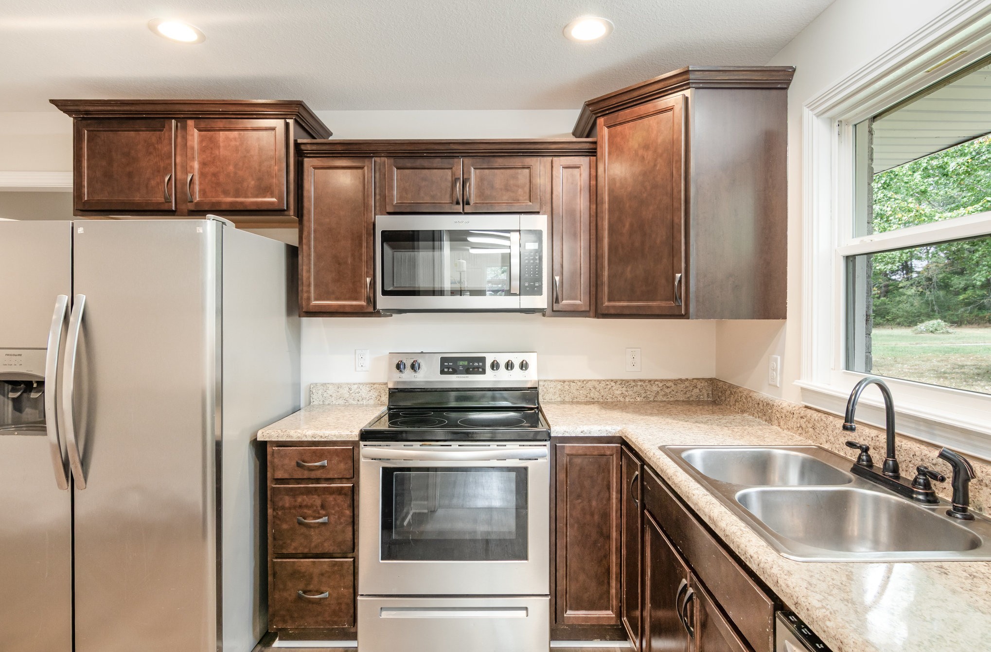 2557 Woodlawn Road Woodlawn, TN 37191 - Photo 15 of 40 a kitchen with stainless steel appliances granite countertop a sink stove and refrigerator