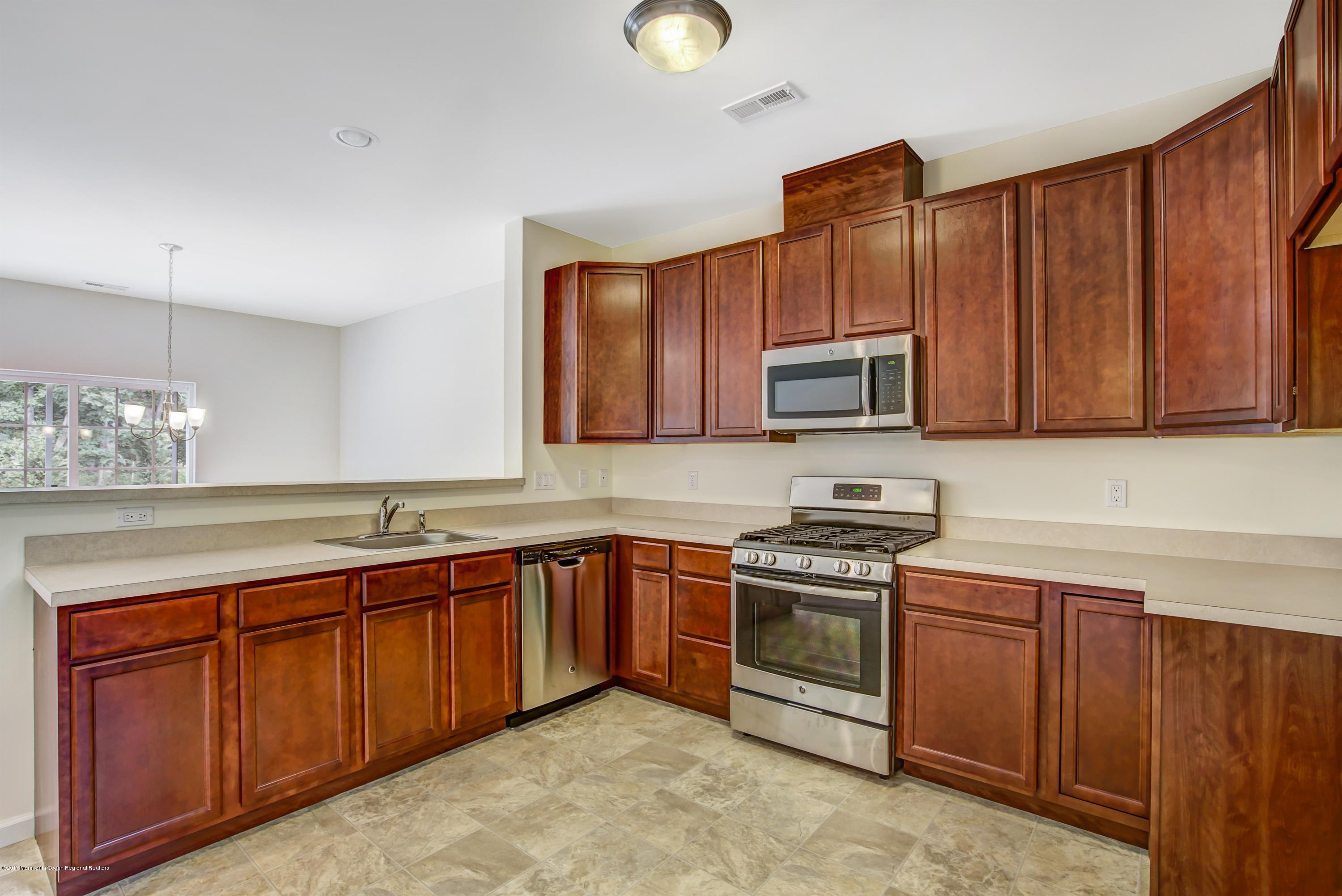 58 Rockingham Way Manchester Township, NJ 08759 - Photo 5 of 18 a kitchen with stainless steel appliances granite countertop wooden cabinets a stove a sink and dishwasher
