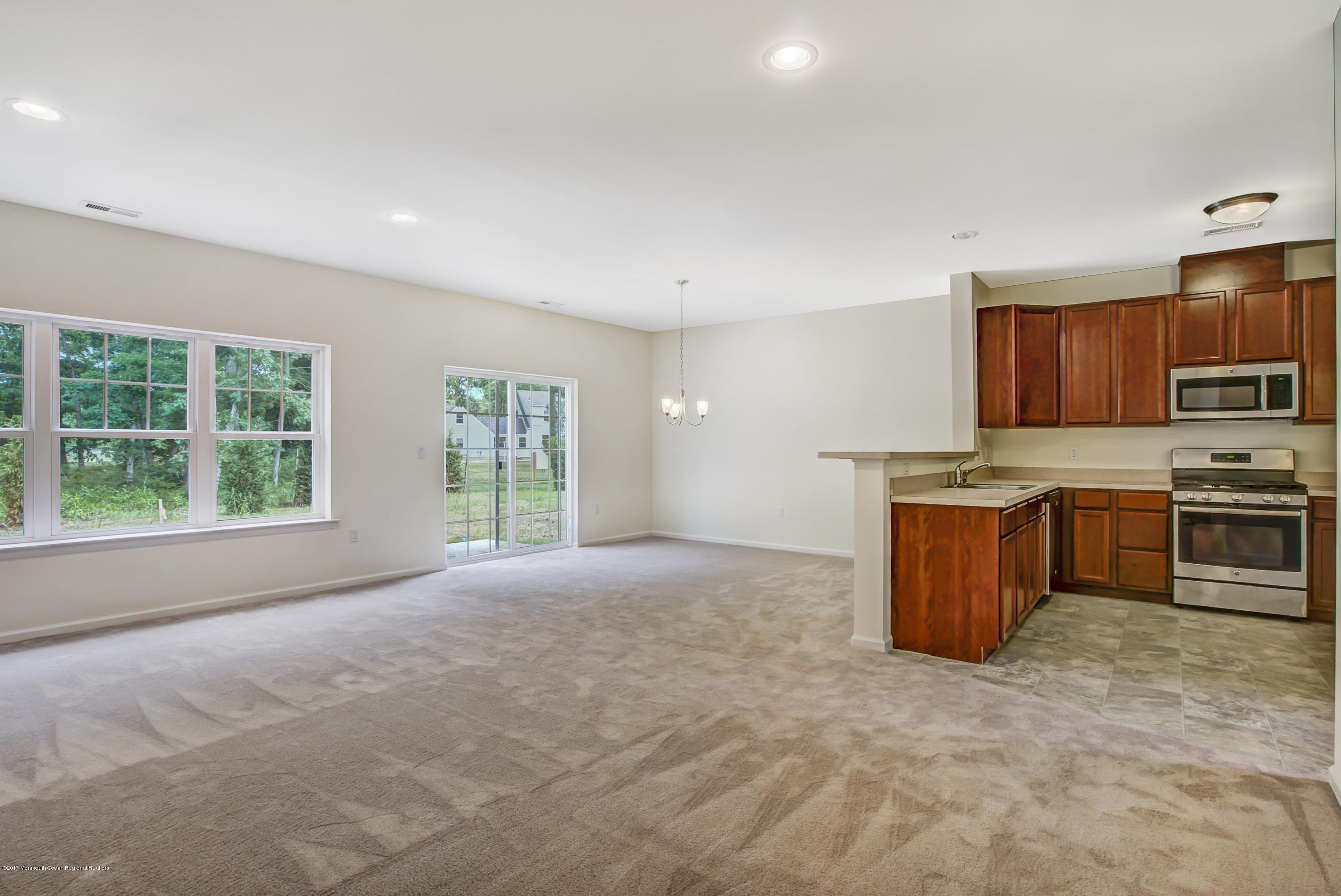 58 Rockingham Way Manchester Township, NJ 08759 - Photo 7 of 18 a view of kitchen with stainless steel appliances granite countertop a stove top oven a sink dishwasher a dining table and chairs with wooden floor