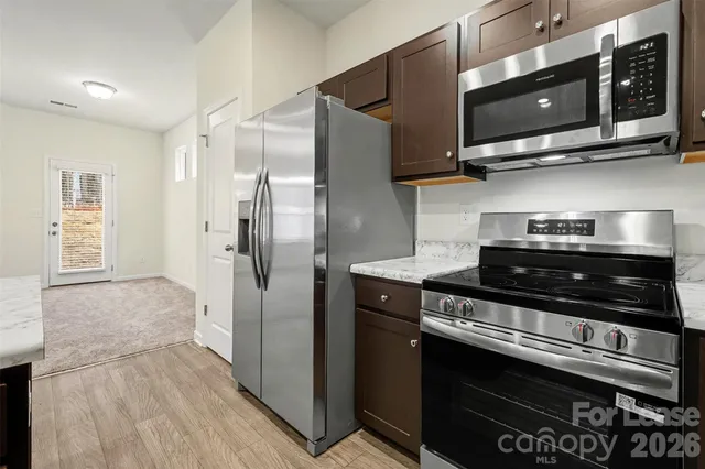 a kitchen with stainless steel appliances and wooden cabinets
