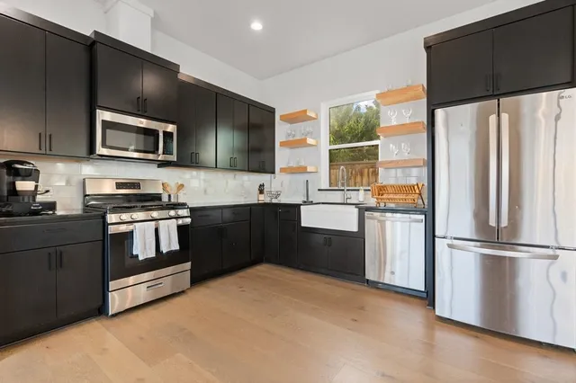 a kitchen with granite countertop a refrigerator and a stove top oven