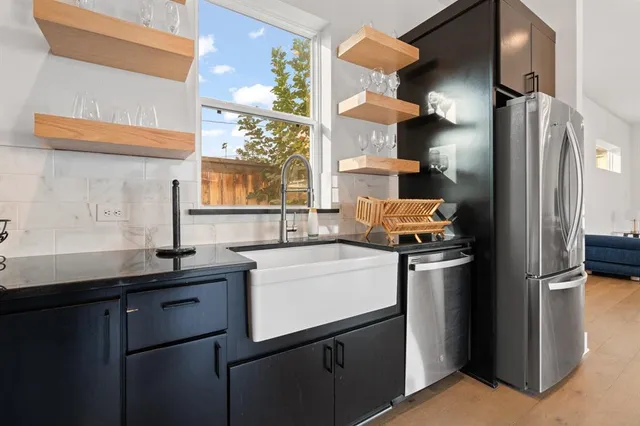 a kitchen with stainless steel appliances granite countertop a refrigerator and a sink