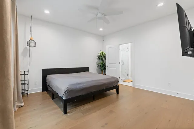 a spacious bedroom with a bed and a flat screen tv