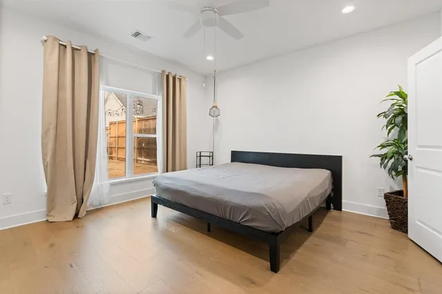 a spacious bedroom with a large bed and a potted plant