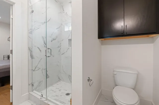 a bathroom with a toilet and shower