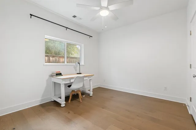 an empty room with a window and a ceiling fan