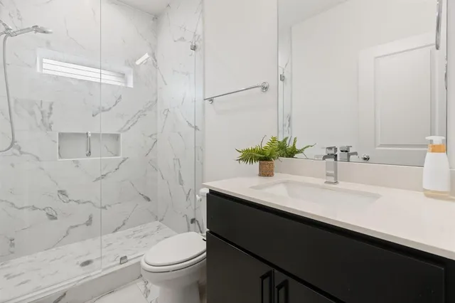 a bed sitting in a spacious bedroom next to a window and a wooden floor