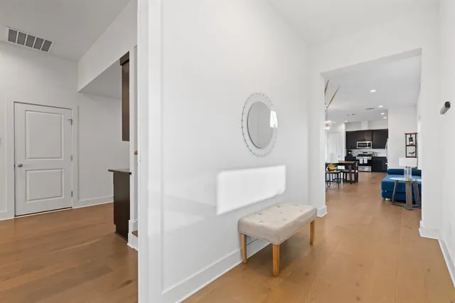 a living room with furniture a flat screen tv and a wooden floor
