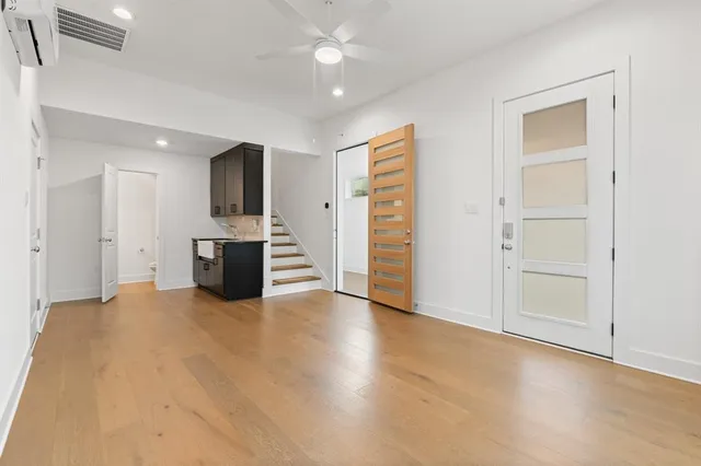 an empty room with kitchen and fireplace