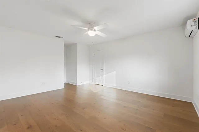 an empty room with an entryway and fan