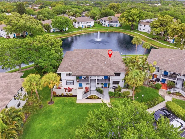 an aerial view of a house with swimming pool big yard and large trees
