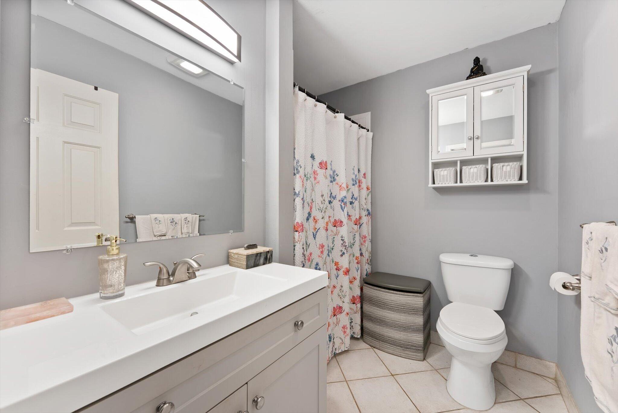 3122 Southwest 20th Terrace, Unit 25B2 Delray Beach, FL 33445 - Photo 11 of 32 a bathroom with a sink a toilet and a mirror