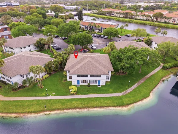 an aerial view of a house with a garden and lake view