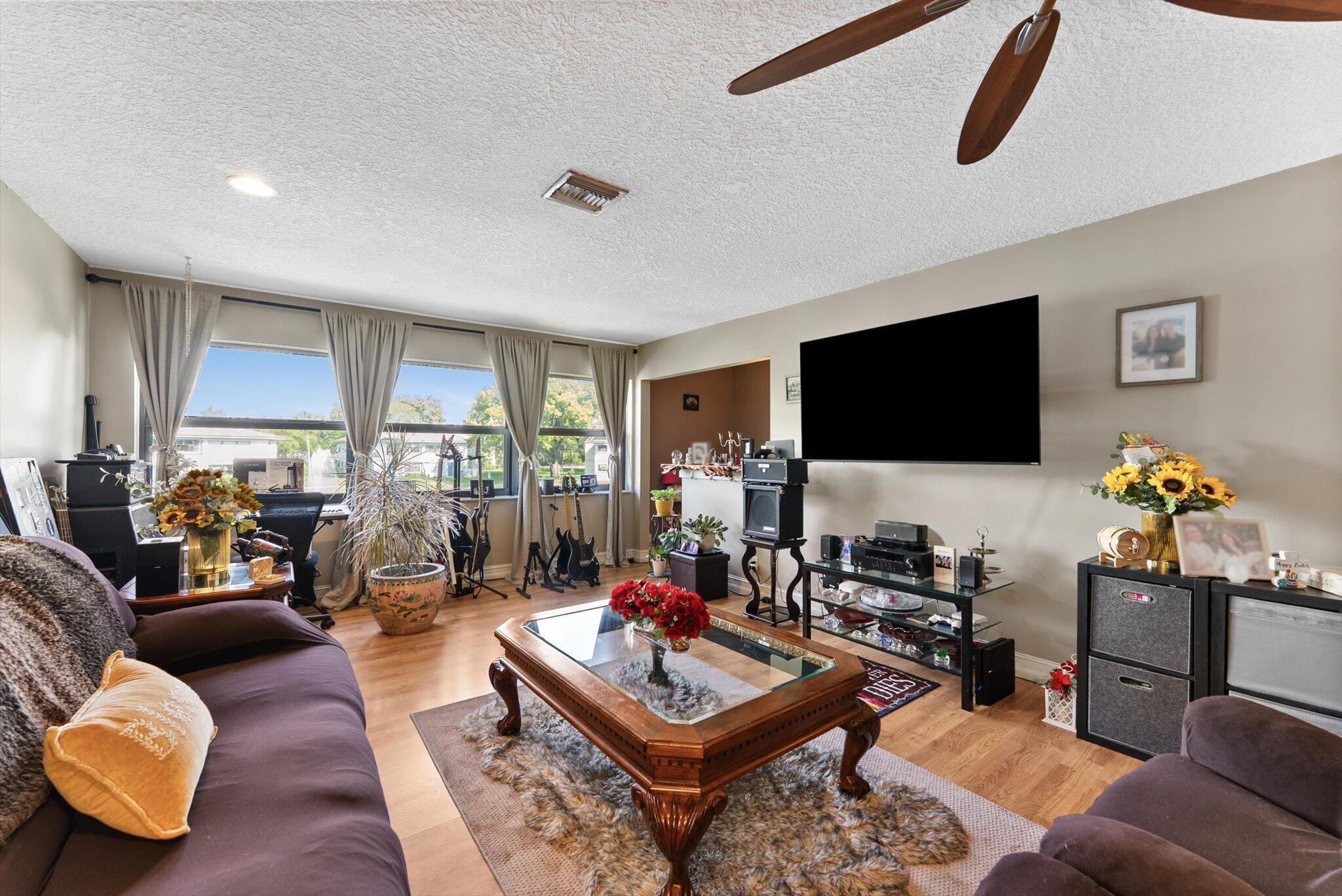 3122 Southwest 20th Terrace, Unit 25B2 Delray Beach, FL 33445 - Photo 4 of 32 a living room with furniture and a flat screen tv