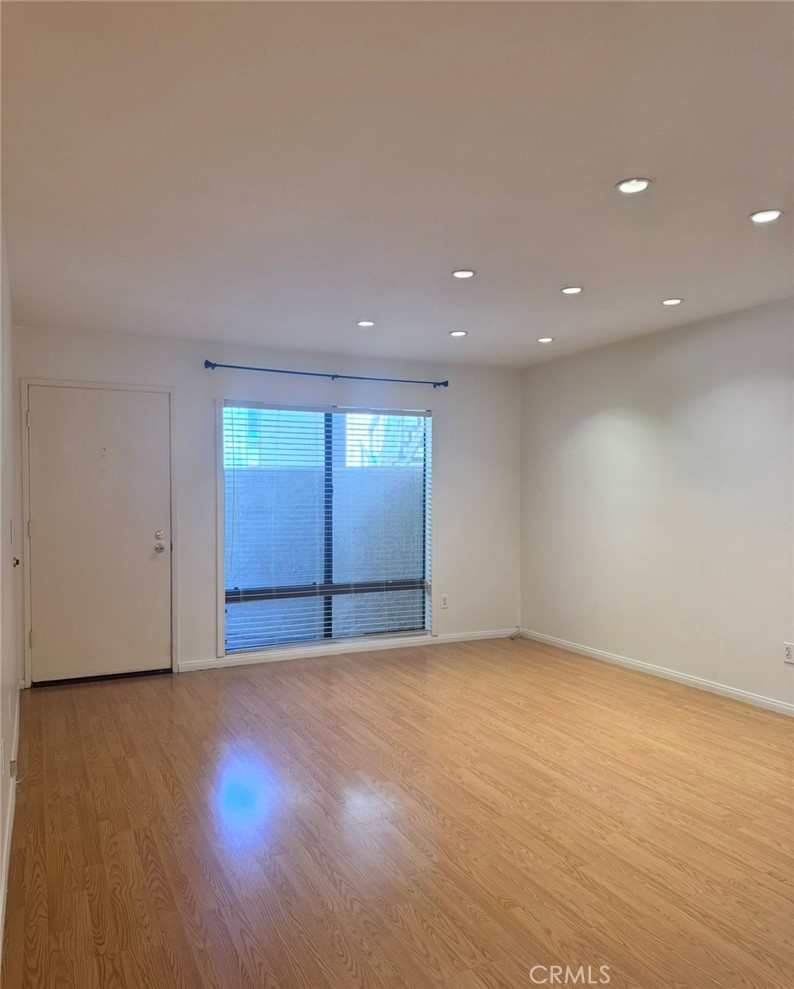 3032 Associated Road, Unit 76 Fullerton, CA 92835 - Photo 13 of 14 an empty room with wooden floor and windows