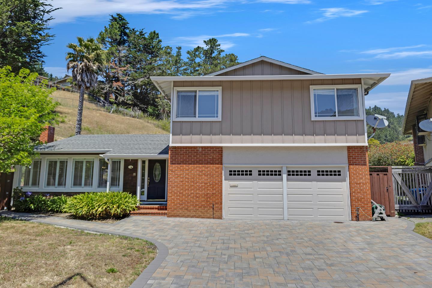 a front view of a house with yard and parking