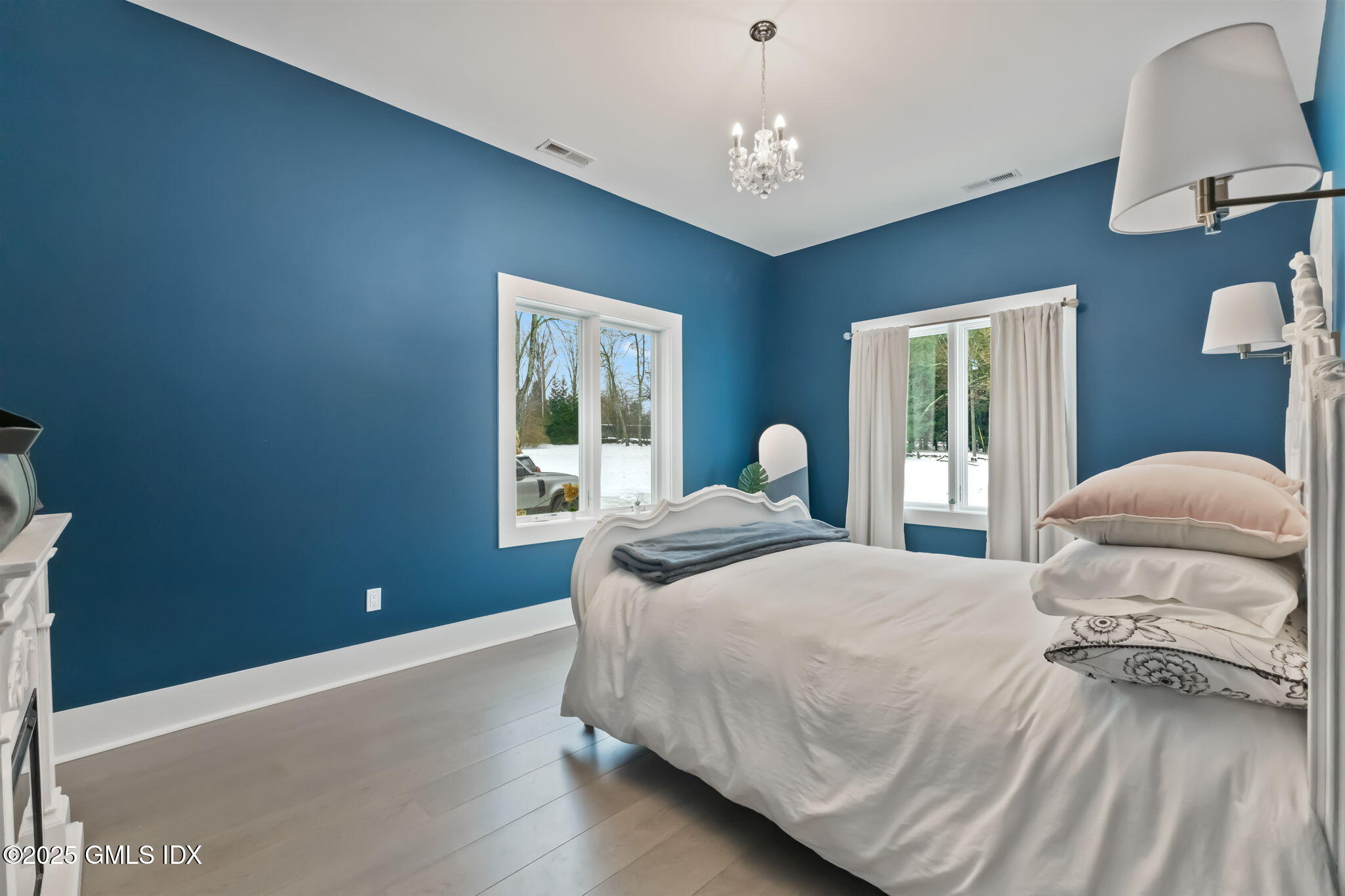 424 Taconic Road Greenwich, CT 06831 - Photo 17 of 35 a bedroom with a large bed and a chandelier