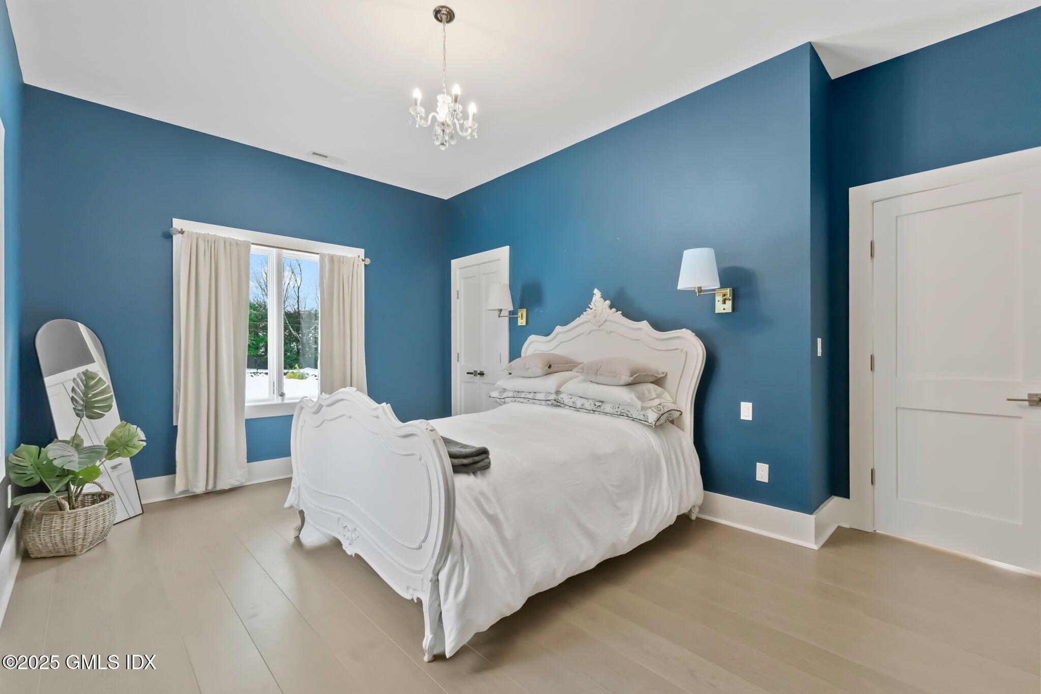 424 Taconic Road Greenwich, CT 06831 - Photo 18 of 35 a bed room with a bed and a chandelier