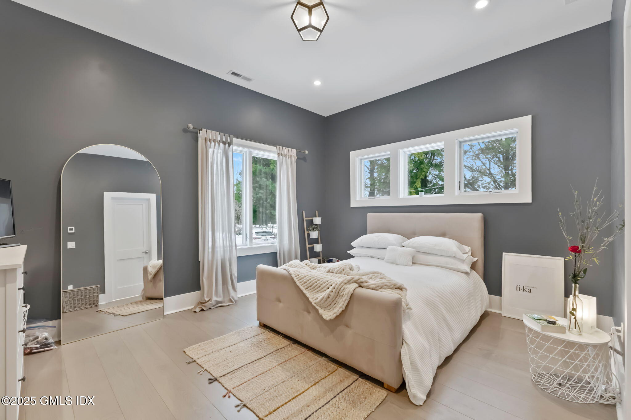 424 Taconic Road Greenwich, CT 06831 - Photo 22 of 35 a bedroom with a large bed and a chandelier