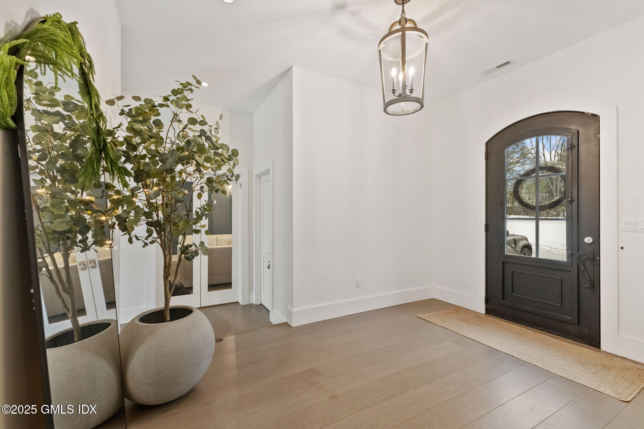 424 Taconic Road Greenwich, CT 06831 - Photo 3 of 35 an entryway with a flower pot and a bookshelf
