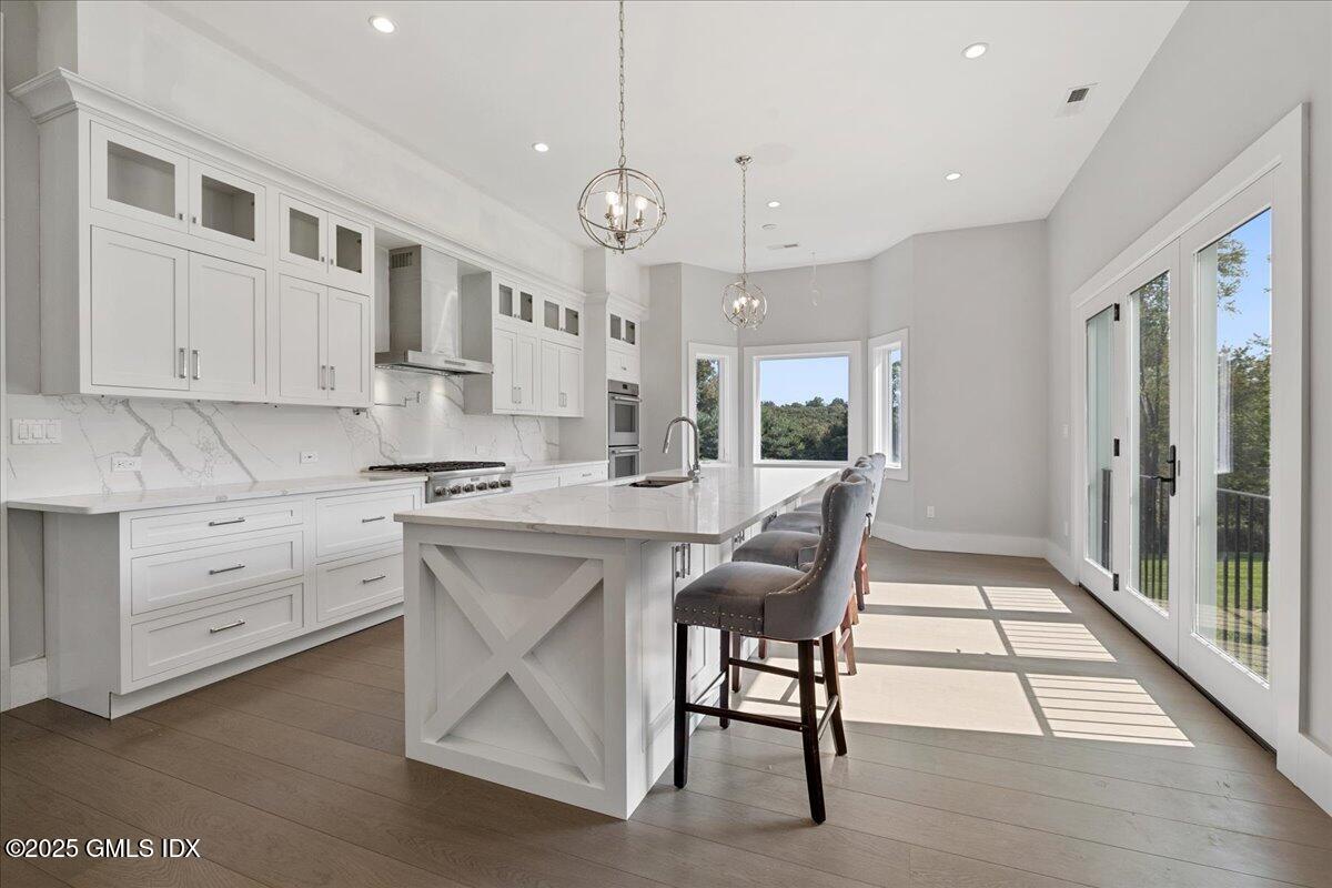 424 Taconic Road Greenwich, CT 06831 - Photo 8 of 35 a large kitchen with kitchen island a large window and stainless steel appliances