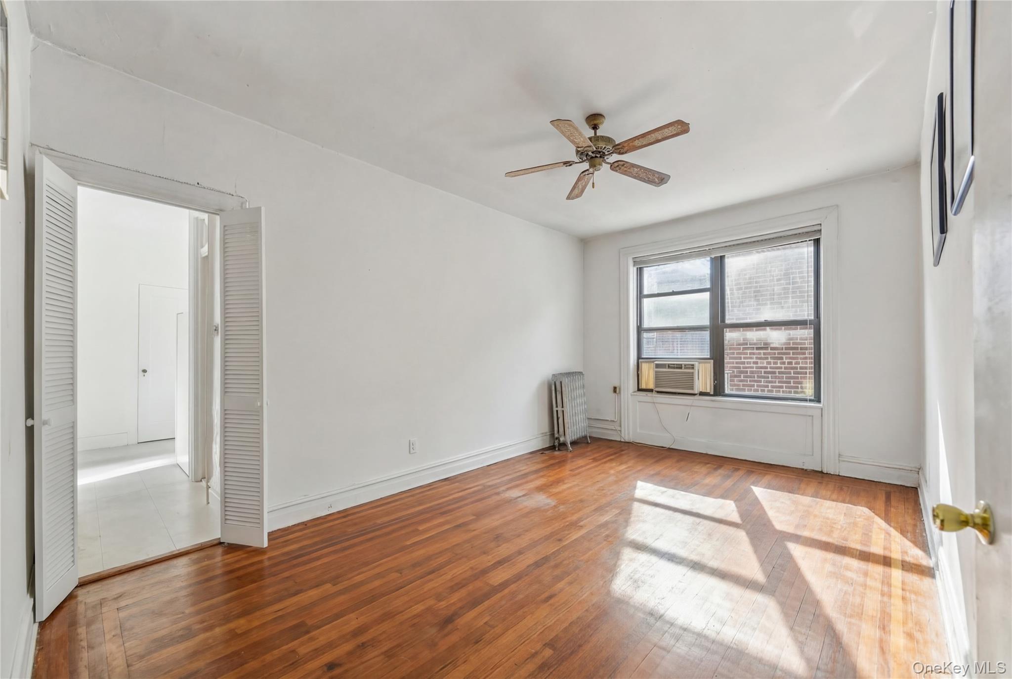 880 West 181st Street, Unit 6G Manhattan, NY 10033 - Photo 2 of 13 a view of empty room with wooden floor and fan