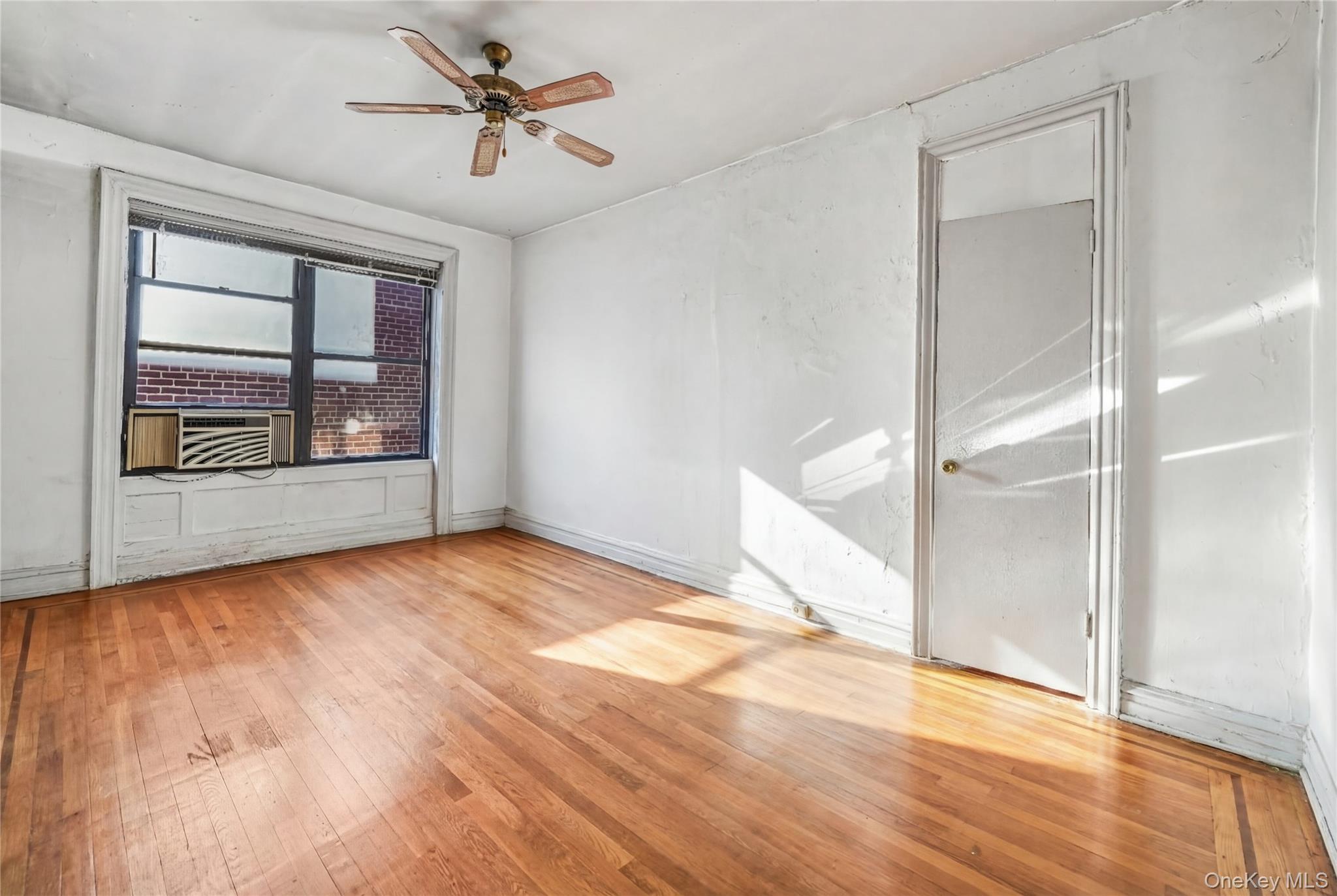880 West 181st Street, Unit 6G Manhattan, NY 10033 - Photo 4 of 13 an empty room with wooden floor chandelier and windows