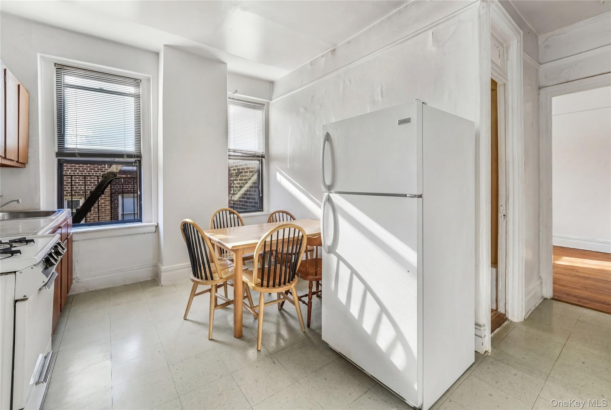 880 West 181st Street, Unit 6G Manhattan, NY 10033 - Photo 5 of 13 a dining room with furniture and a refrigerator