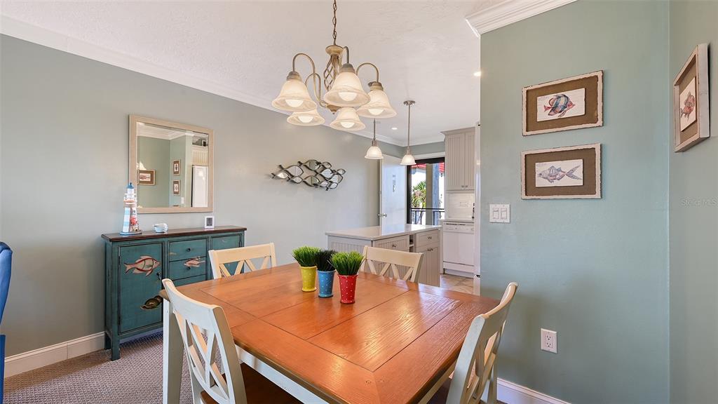 925 Beach Road, Unit 311 Sarasota, FL 34242 - Photo 12 of 53 a view of a dining room with furniture and wooden floor