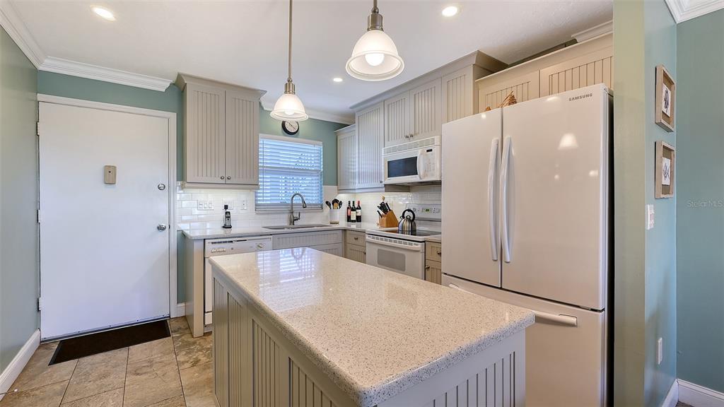 925 Beach Road, Unit 311 Sarasota, FL 34242 - Photo 13 of 53 a kitchen with a refrigerator a sink and cabinets