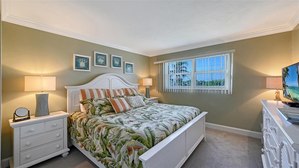 925 Beach Road, Unit 311 Sarasota, FL 34242 - Photo 16 of 53 a bedroom with a bed and lamp