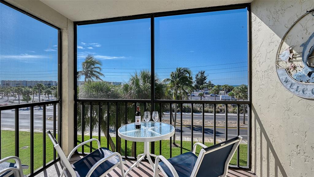 925 Beach Road, Unit 311 Sarasota, FL 34242 - Photo 21 of 53 a view of a balcony with chairs and wooden floor