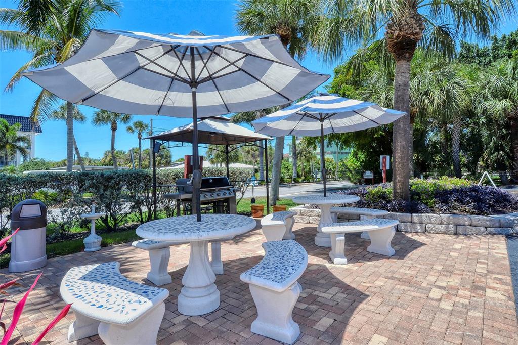 925 Beach Road, Unit 311 Sarasota, FL 34242 - Photo 36 of 53 a view of a patio with couches table and chairs under an umbrella
