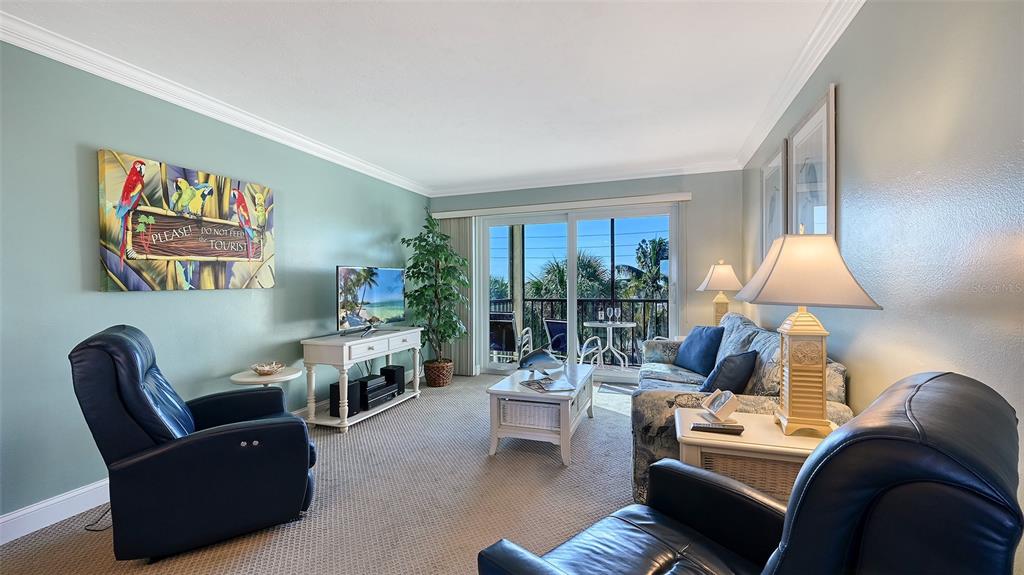 925 Beach Road, Unit 311 Sarasota, FL 34242 - Photo 8 of 53 a living room with furniture and a lamp