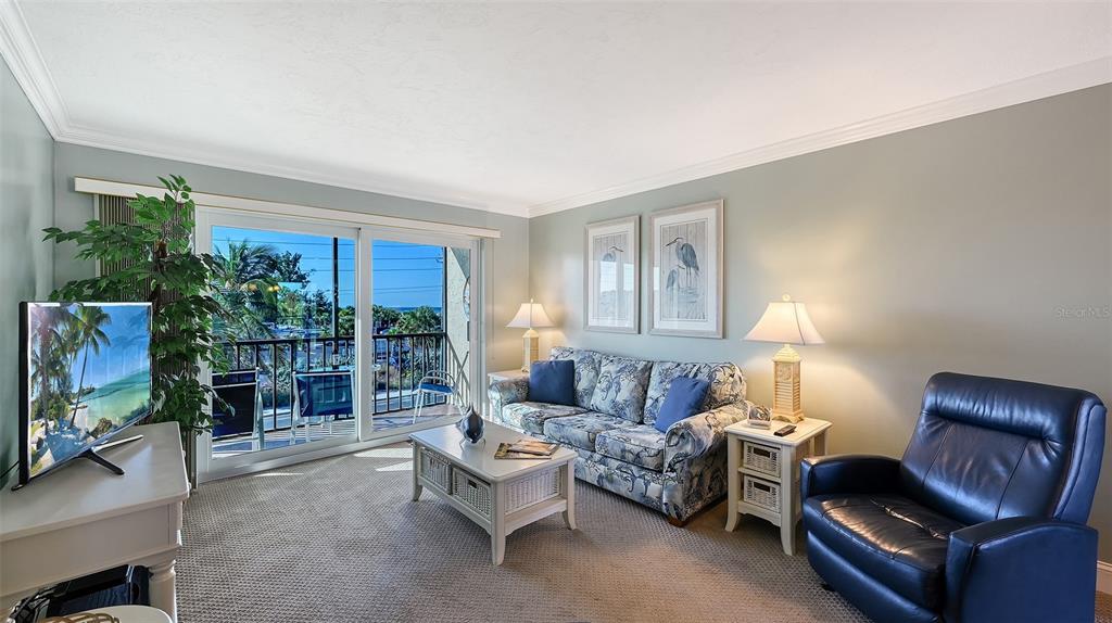 925 Beach Road, Unit 311 Sarasota, FL 34242 - Photo 10 of 53 a living room with furniture a flat screen tv and a window