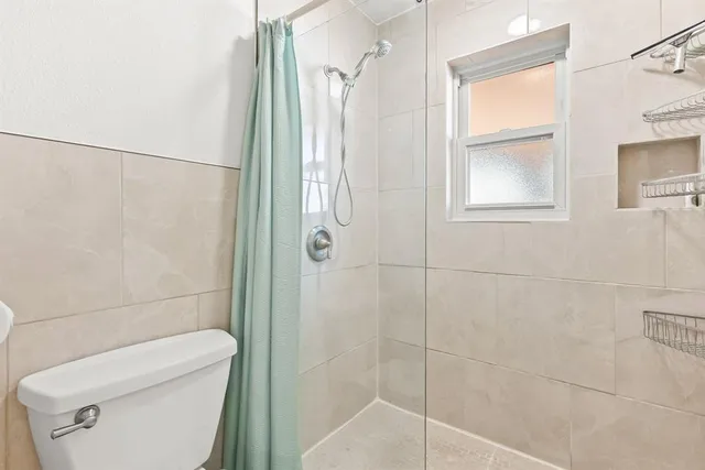a bathroom with a toilet and a shower