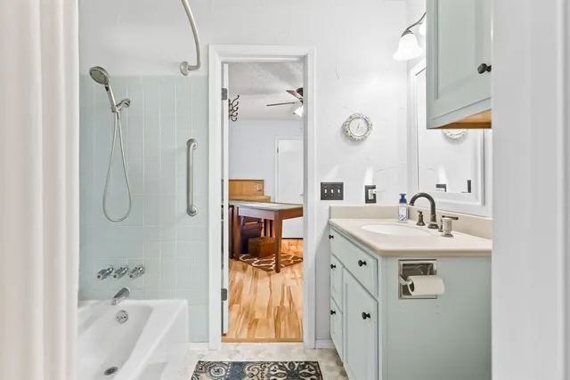 a spacious bathroom with a tub sink and mirror