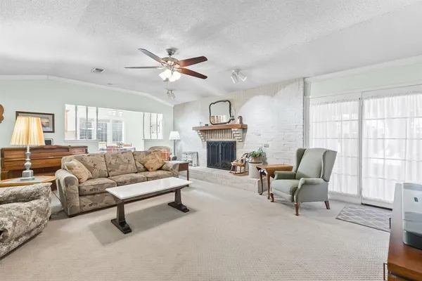 a living room with furniture a fireplace and a large window