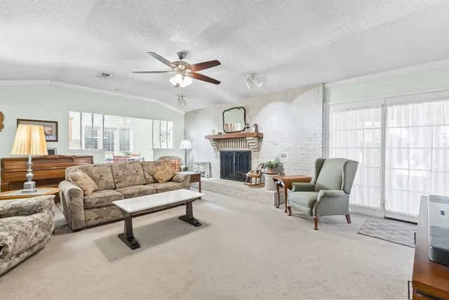 a living room with furniture a fireplace and a large window