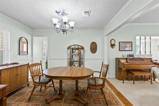 a view of a dining room with furniture and chandelier