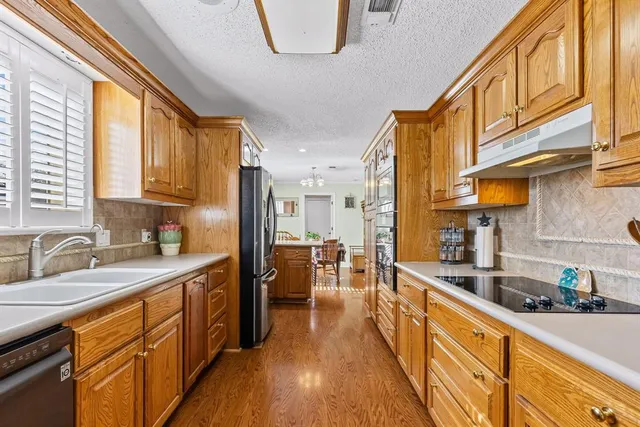 a kitchen with stainless steel appliances a sink a stove and a refrigerator