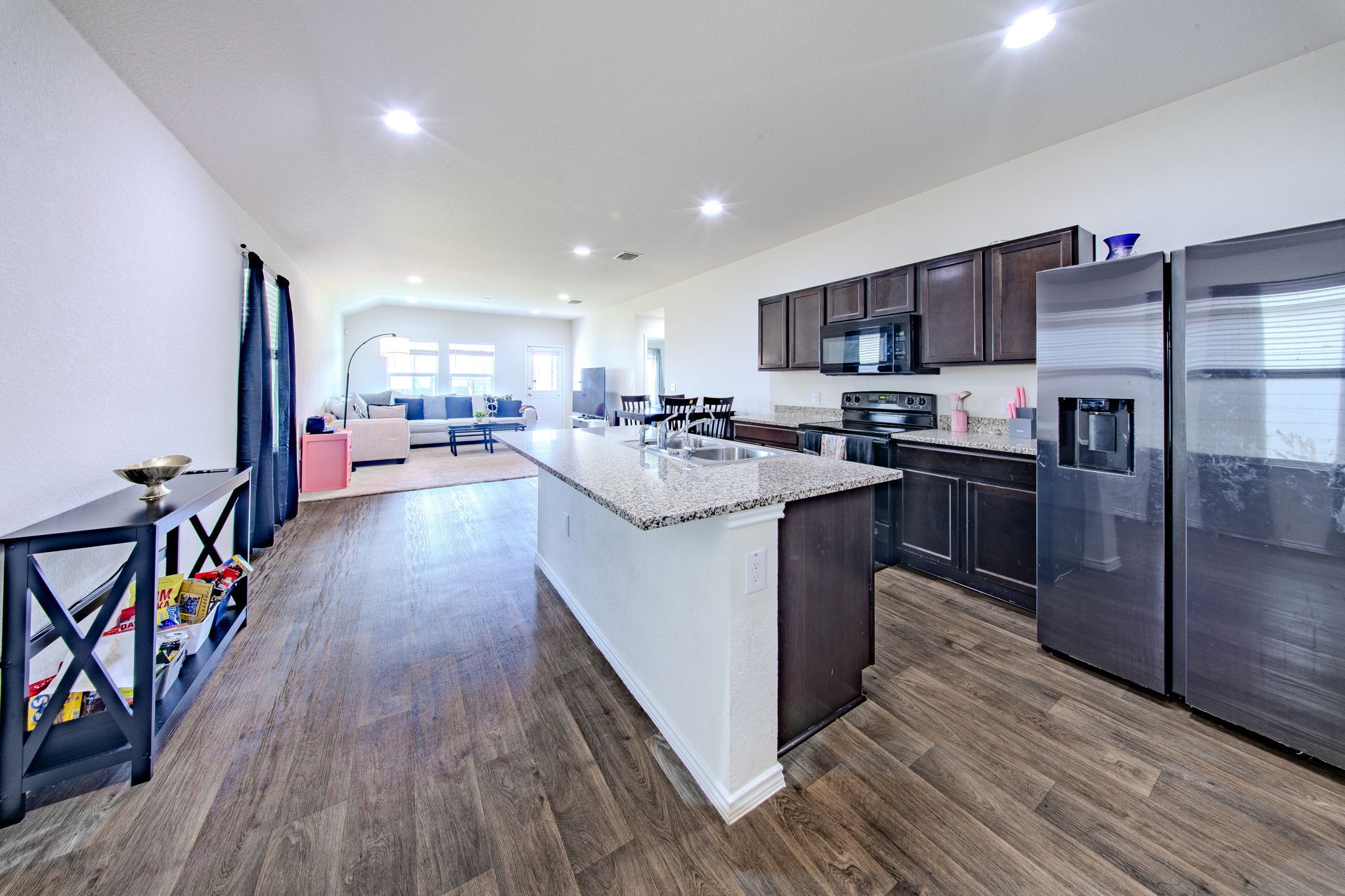14903 Tuff Road Manor, TX 78653 - Photo 5 of 25 Granite counters and stainless steel appliances adorn this open concept kitchen with wood flooring.