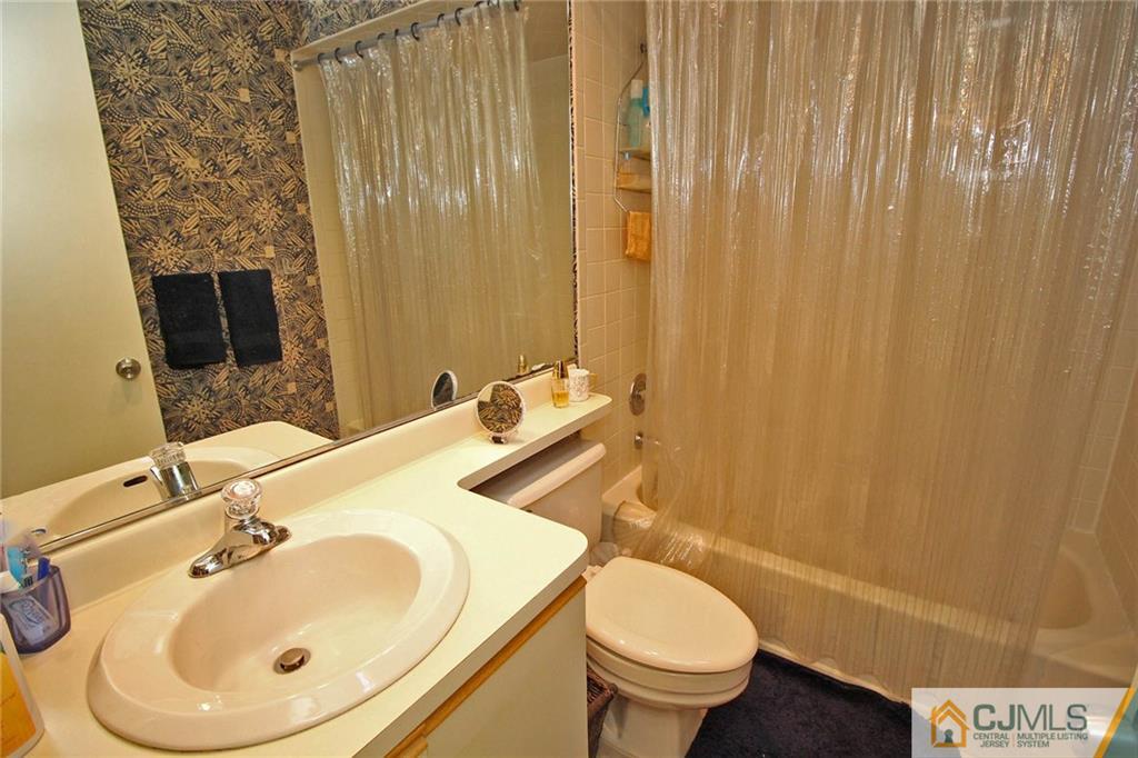 4004 Springbrook Drive Edison, NJ 08820 - Photo 20 of 25 a bathroom with a sink a toilet and shower curtain