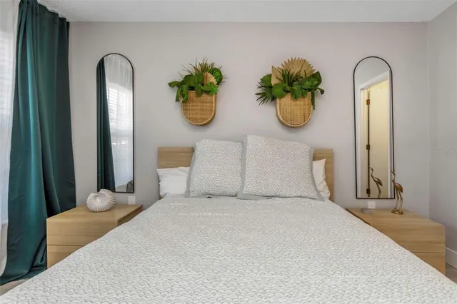 a bedroom with a bed and a potted plant