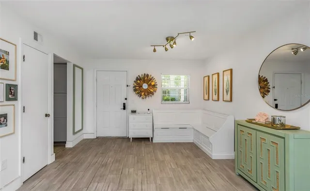 a view of a bedroom with wooden floor cabinet and window