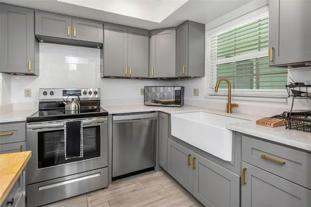 a kitchen with stainless steel appliances granite countertop a sink a stove and cabinets